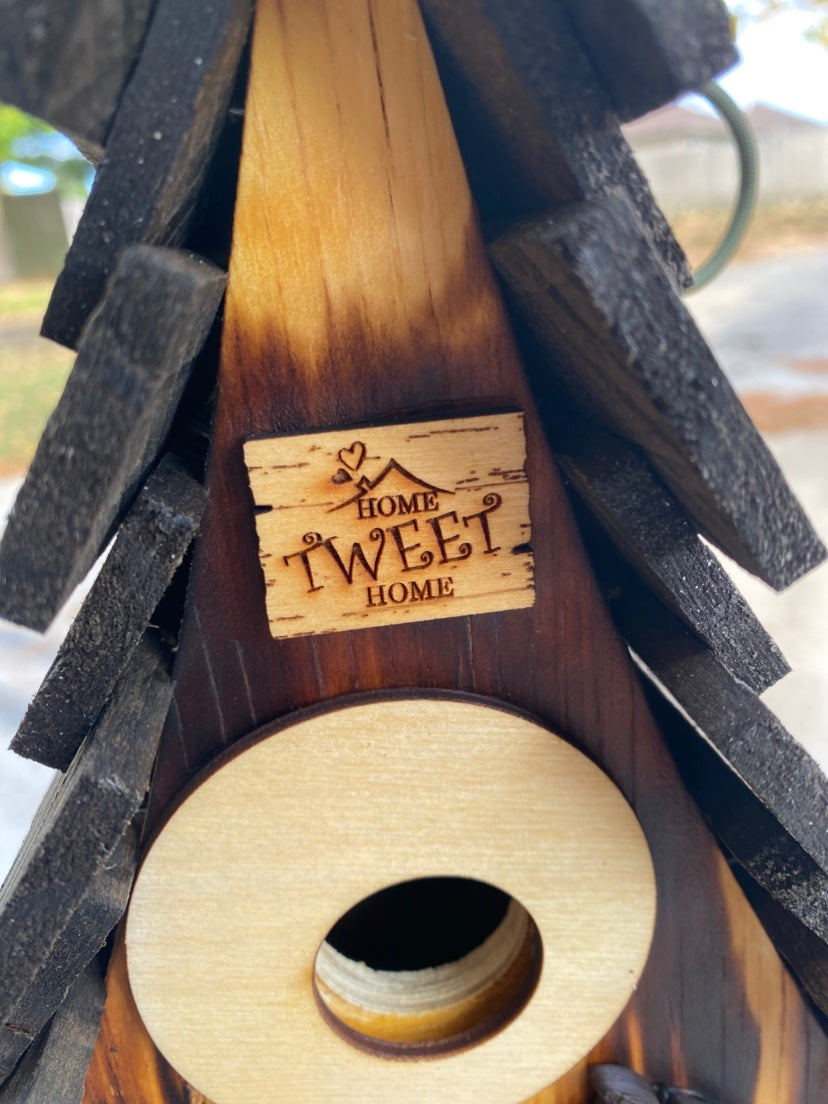 Close-up of the Home Tweet Home plaque and round entrance on the Burned A-frame birdhouse